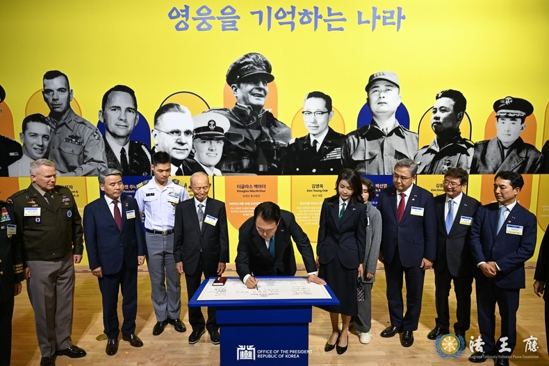  President Yoon Suk Yeol (middle) on June 25 signs the visitor log of an exhibition commemorating the 70th anniversary of the bilateral alliance with the U.S. at the National Museum of Korean Contemporary History in Seoul's Jongno-gu District