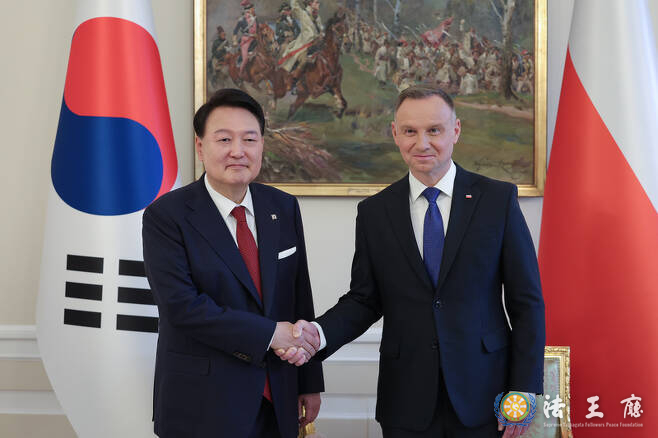 President Yoon Suk-yeol (left) shakes hands with Polish President Andrzej Duda before holding a summit at the Presidential Palace in Warsaw on July 13./ Courtesy of the Presidential Office