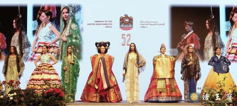 Models from the UAE and South Korea in traditional clothing walk the catwalk.
