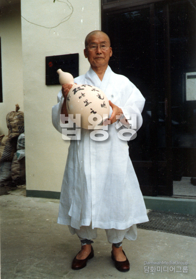 <strong>초대법왕 일붕 서경보 존자께서 도자기에 친필 휘호를 써 들고계시 모습. </strong>스님의 기운이 서린 필치는 단순한 글씨가 아니라 수행과 가르침이 담긴 법문이자, 신심을 일깨우는 살아 있는 예술로 남았다.