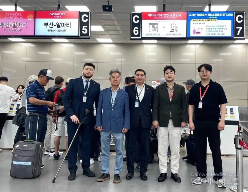 아슬란 아스카르 총영사, 이상훈 명예영사, 이스타항공 직원 및 카자흐스탄 총영사관 관계자들이 부산–알마티 노선 체크인 카운터 앞에 함께 서 있다.